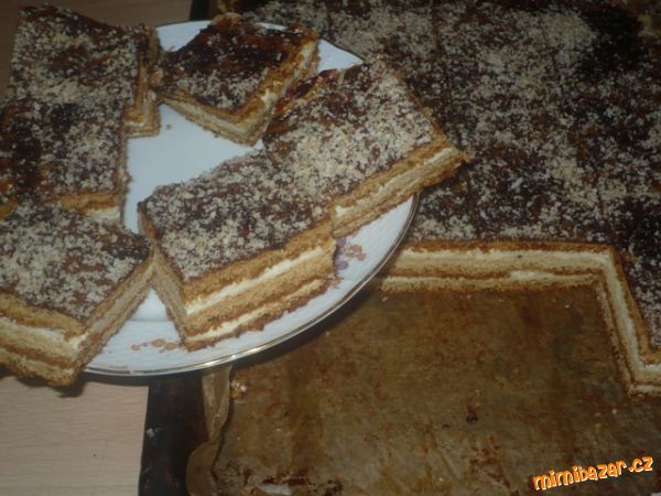 Medové řezy s čokoládovou polevou sypané strouhanými ořechy.